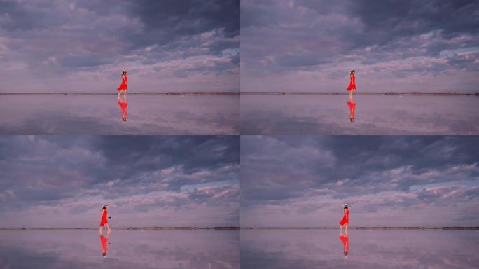 一名年轻女子在一个粉红色的湖上漫步，云彩在湖中倒映。