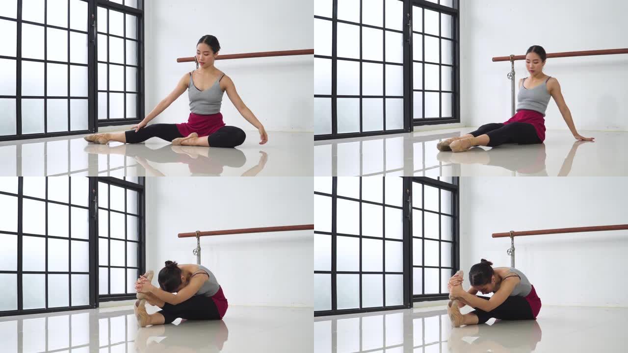 侧视图: 年轻的芭蕾舞女坐着时伸展腿