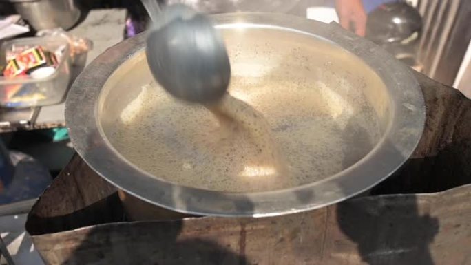 一个印第安人在混乱的印度新德里的一条小巷里准备著名的柴茶的慢动作视频。