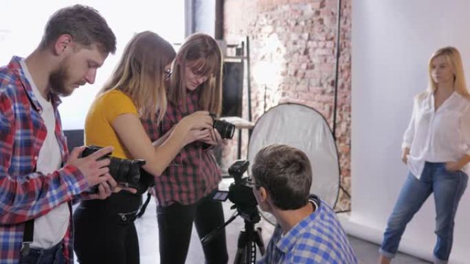 摄影工作室，摄影师公司讨论在专业工作室培训期间安装单反相机