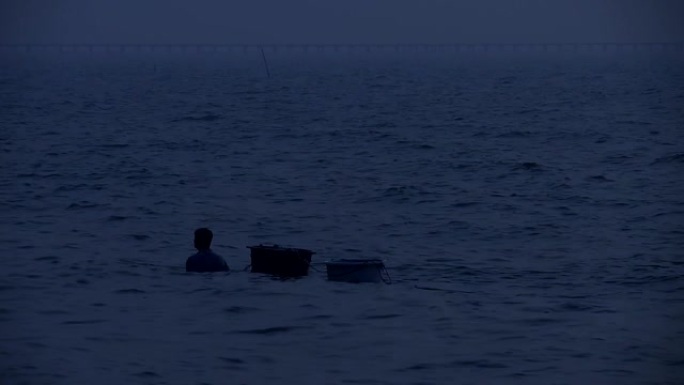 男子在日落之后拖了两盆精美的海鲜