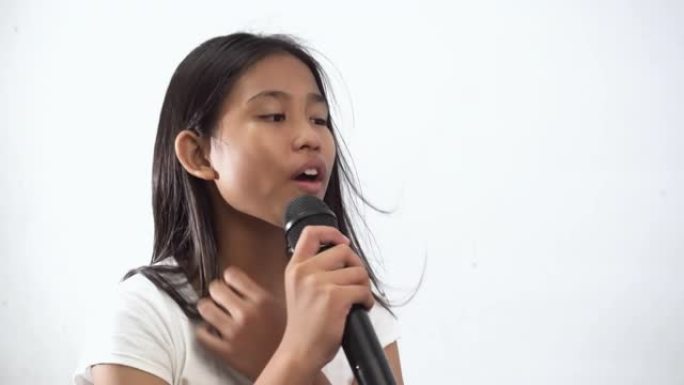 一个可爱的小女孩在白色背景上唱歌的特写镜头