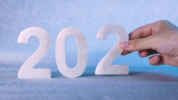 换手2019 2020年，新年即将到来的概念，2020庆祝倒计时。特写。银色背景和数字。