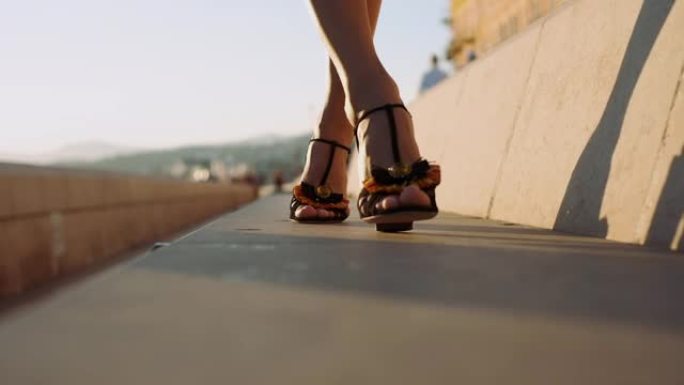 穿着高跟鞋的女性腿在城市街道上行走。