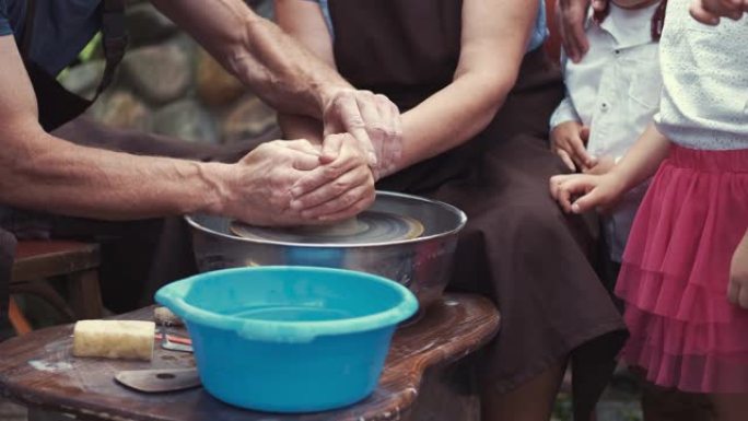 有孙子的祖父母用陶器制作水罐