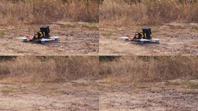 FPV赛车无人机从尘土表面起飞，扬起灰尘和石头