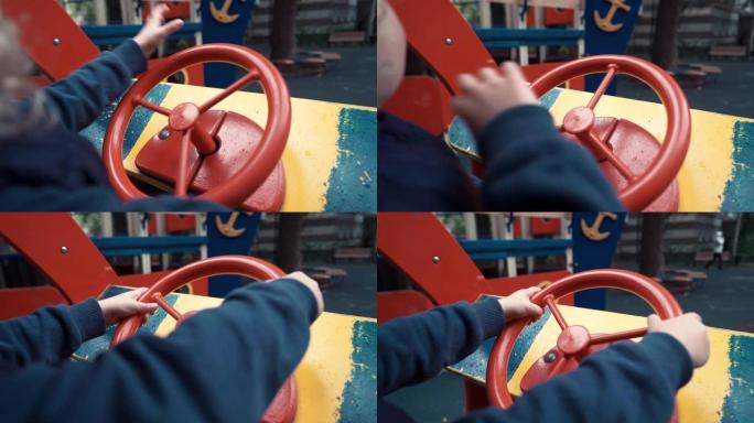 男孩坐在操场上的木车里玩耍。摄像机监控坐在玩具车里的孩子。