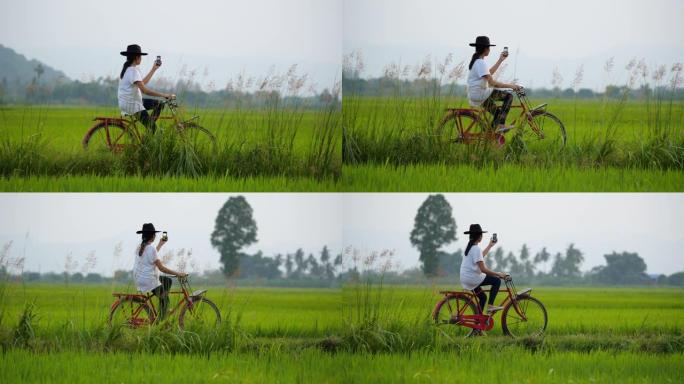 亚洲女子骑自行车在稻田里自拍