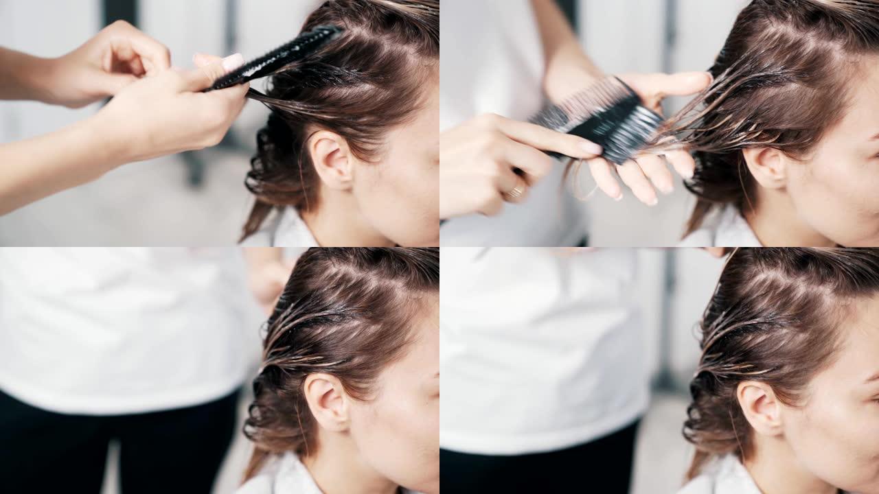 美发师手在年轻女性头发上涂抹发膜的特写