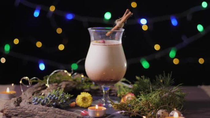 自制传统圣诞蛋酒玻璃饮料，磨碎肉豆蔻和肉桂装饰，圣诞树和灯，为庆祝节日做好准备