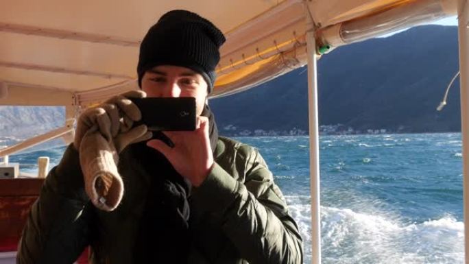 游客在海上用手机在船上拍照
