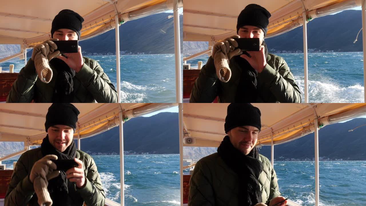游客在海上用手机在船上拍照