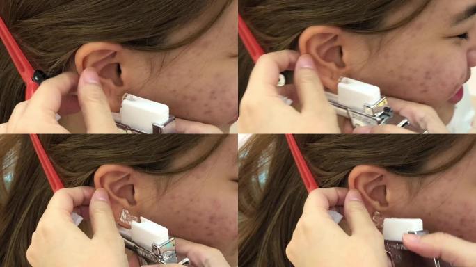 美容师在美容院做耳洞手术