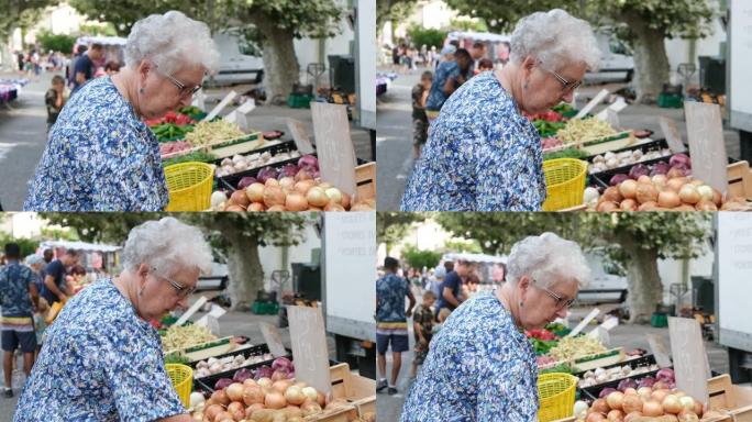 法国普罗旺斯夏季，老年妇女在农贸市场购买新鲜蔬菜和水果