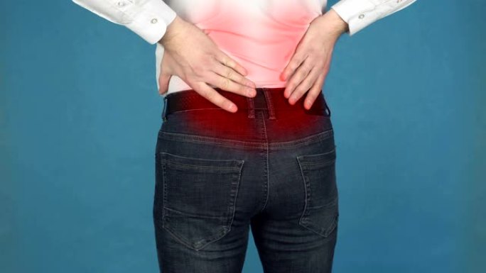 疼痛的肌肉的腰部或下背部脊柱，神经根炎的概念，由于长期工作在计算机。一个穿着白衬衫的男人在背部的神经