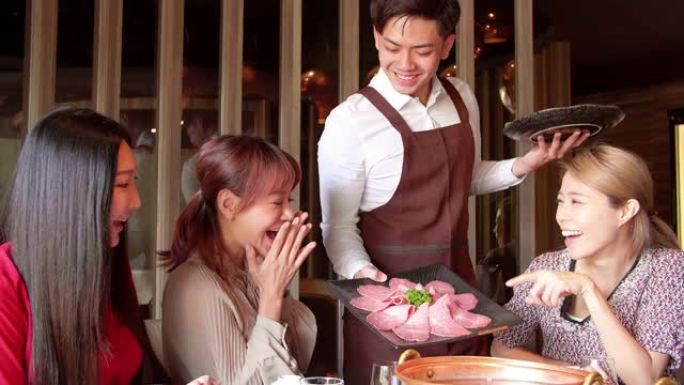 快乐的服务员在餐厅带来火锅和海鲜服务群。