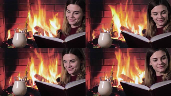 美丽的年轻女孩在传统鸡尾酒蛋酒附近的一本书中读圣诞故事，在壁炉旁对火