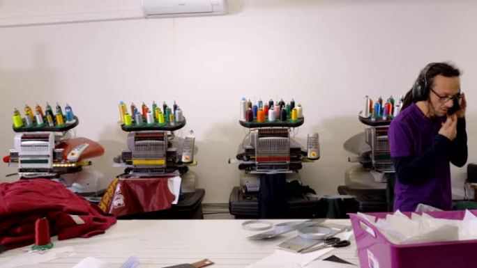 工业刺绣: 刺绣工人在他们的工作室里使用机械
