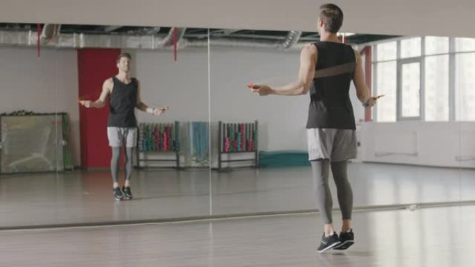 运动员男子在健身俱乐部的有氧训练中跳绳。