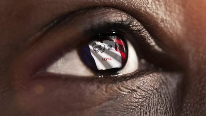 女人黑眼圈在近距离与爱荷华州的国旗虹膜，美国与风运动。视频的概念