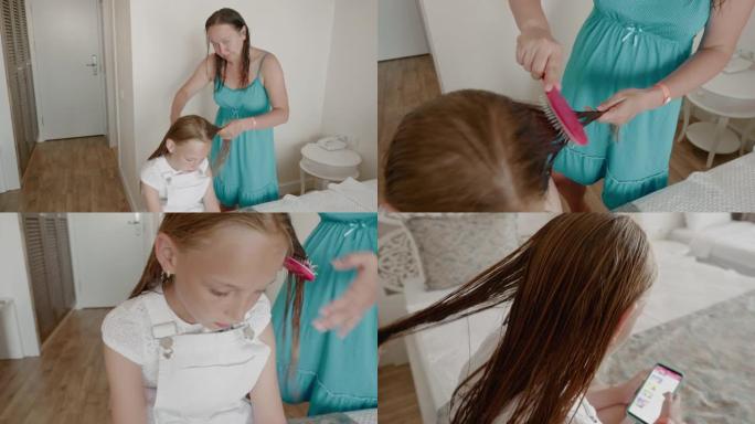 美丽的年轻女子用智能手机给可爱的女儿梳头