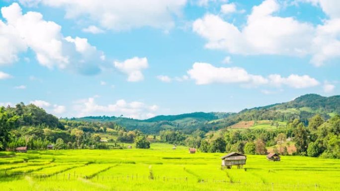 泰国炎热的夏日，4k延时拍摄在晴朗的蓝天中移动的白云，阳光穿过山脉，稻田和小小屋