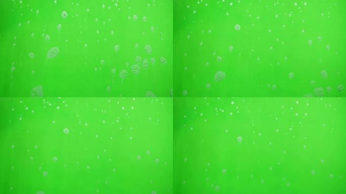 肥皂在绿色背景上流动的泡沫。