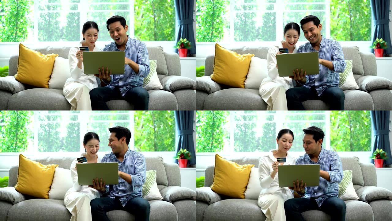 4k微笑夫妇拿着Visa信用卡，一边用笔记本电脑在线购物