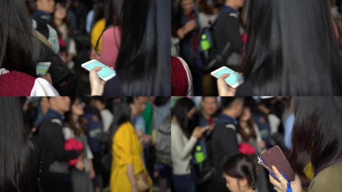 4k亚洲妇女与排长队的人群一起检查智能手机