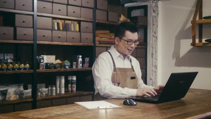 亚洲男经理在他的鞋店做会计