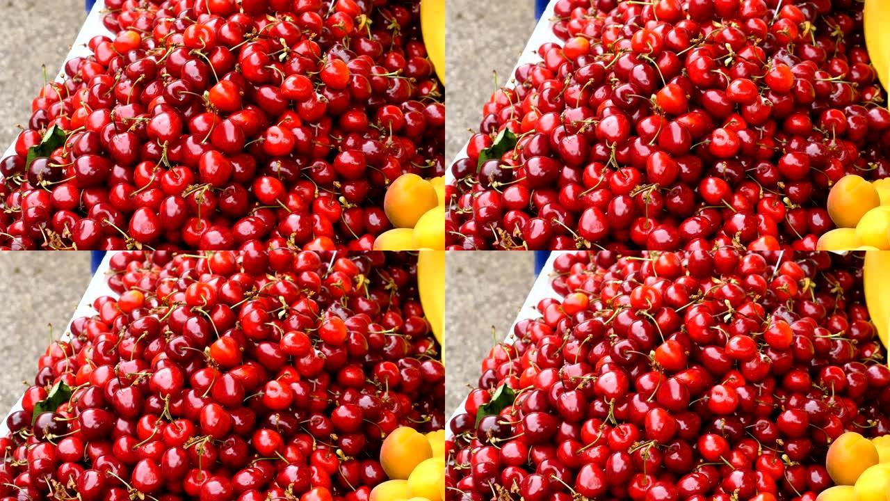 甜樱桃和杏。食品市场上成熟的红樱桃，杏子的特写镜头。4K