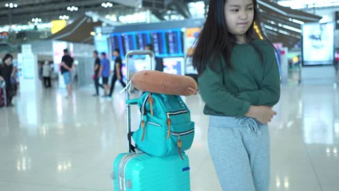 亚洲小女孩在机场的旅程，等待她的航班，面部表情，胃痛，患有膀胱炎，触摸腹部并感到疼痛