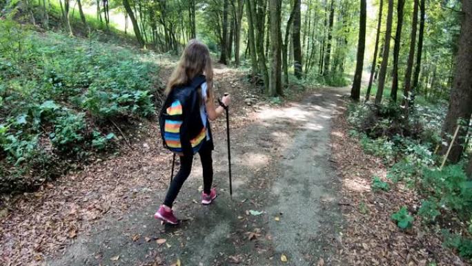 快乐的少女背着背包走在森林里