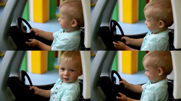 年轻司机。孩子用玩具车关上门，控制方向盘。一岁的男婴。侧视图。儿童游戏中心。