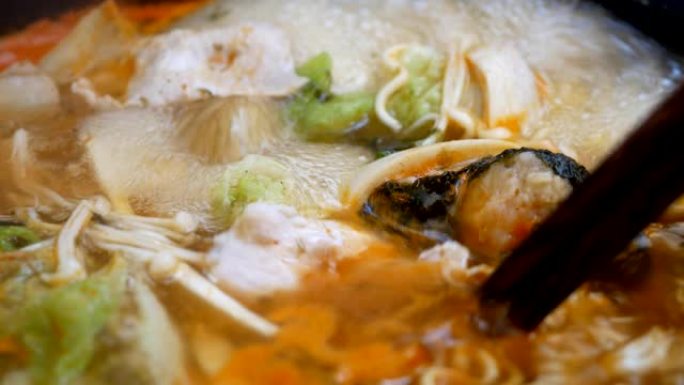 火锅煮沸牛肉拉米面条泡菜Chigae汤的特写镜头