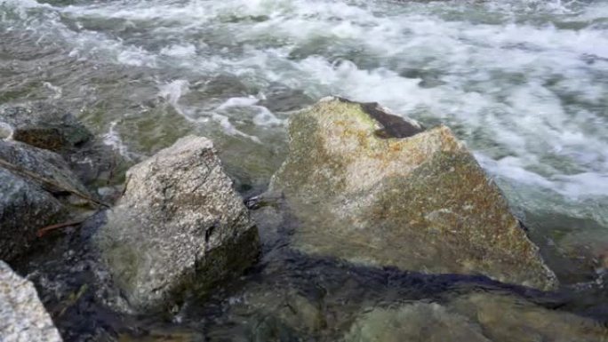 野生水流-流动的河流形成白浪，前景中的大尖锐岩石