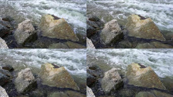 野生水流-流动的河流形成白浪，前景中的大尖锐岩石