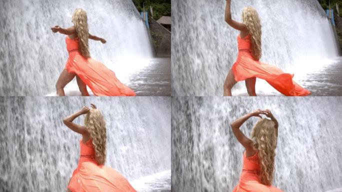 穿着橙色连衣裙的年轻女子站在喷水下