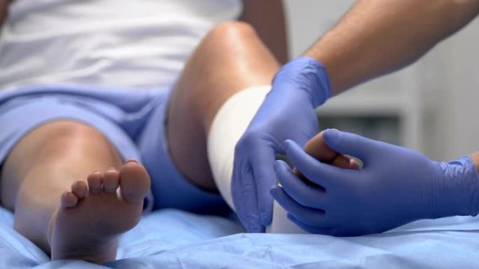 医生检查患者腿部弹性绷带，创伤康复医学