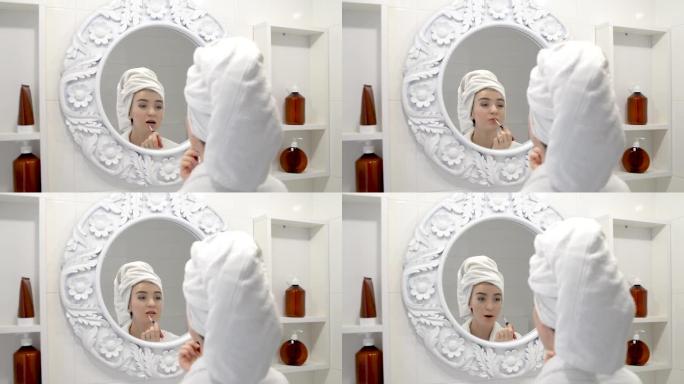 女人在浴室用唇刷在嘴唇上涂口红。