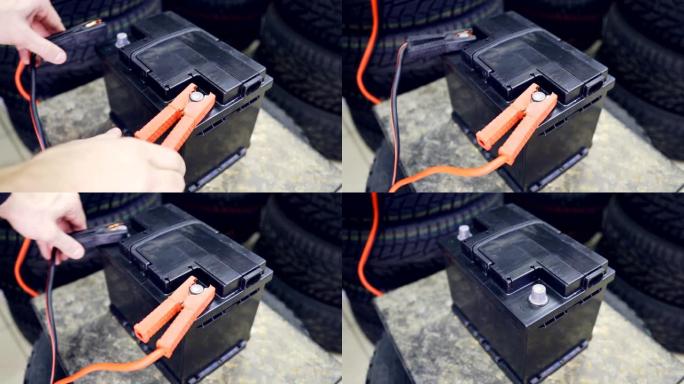 男性的手将端子连接到汽车的电池上。一名男子投掷并移除电池上的端子