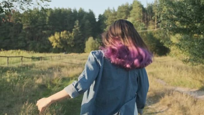年轻女孩用飘动的紫色头发跑她的背