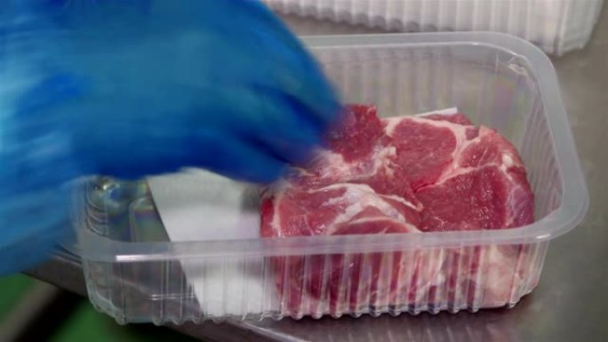 工人在肉类工厂包装切碎的肉