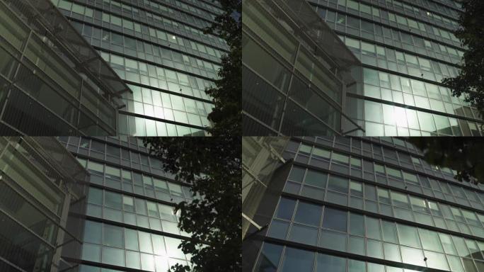 带有阳光反射的灰色摩天大楼，巴黎商业区的绿色玻璃窗，缓慢的steadicam运动跟踪，低角度拍摄。蓝