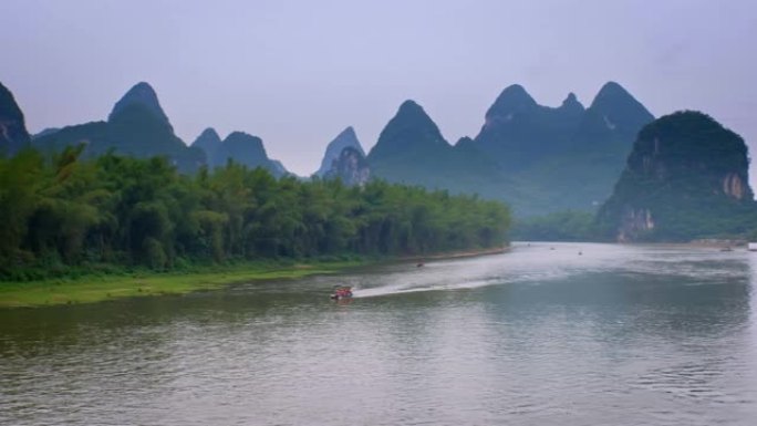 漓江上的旅游船以卡斯特山脉为背景