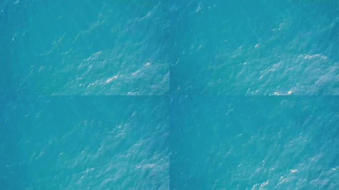 从高空空中俯视蓝色天蓝色绿松石海水纹理。摄像机飞过水面，一览表水面。水面的背景。4k鸟瞰图