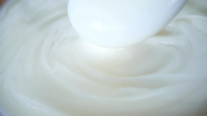 关闭发酵乳益生菌酸奶，健康食品，用勺子混合奶油凝乳