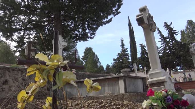4k西班牙乡村墓地，有墓碑、旧白色十字架和柏树