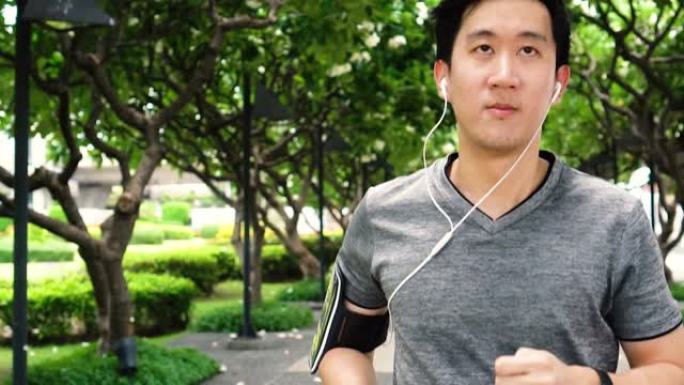 亚洲年轻人在公园听音乐时慢跑的慢动作视频