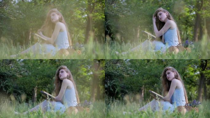 穿着夏装的漂亮女孩坐在草地上，在户外享受大自然。